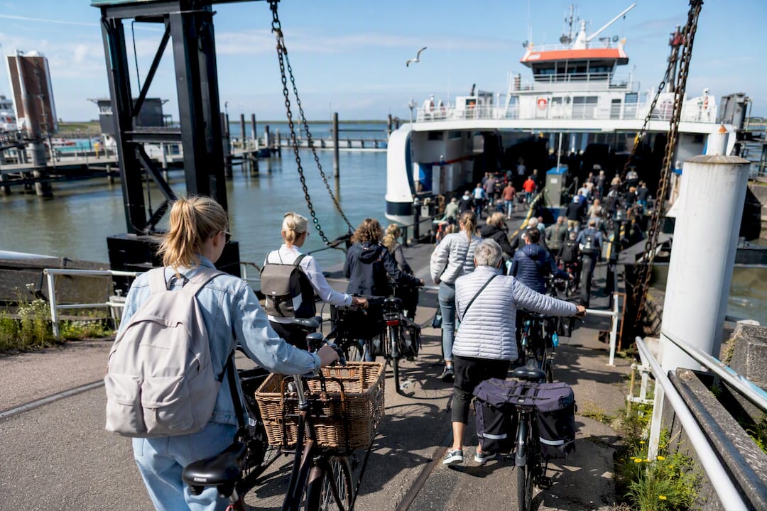 Voetgangers en fietsers stappen op de veerboot naar Ameland