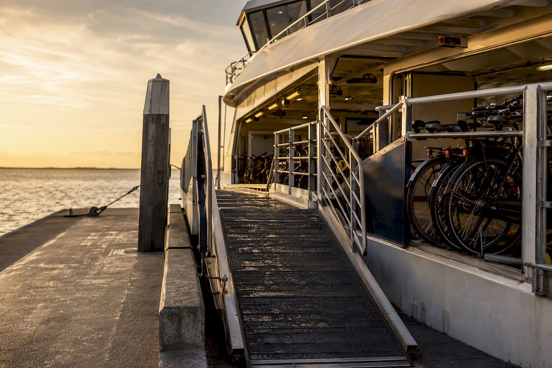Fietsen stappen aan boord van de Amelandveerboot bij terminal Nes