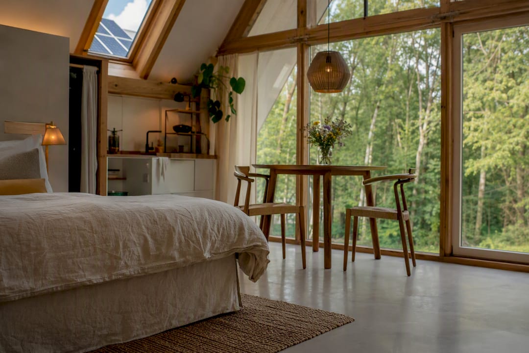 Ecoluxe loftinterieur met natuurlijke materialen en uitzicht op de duinen