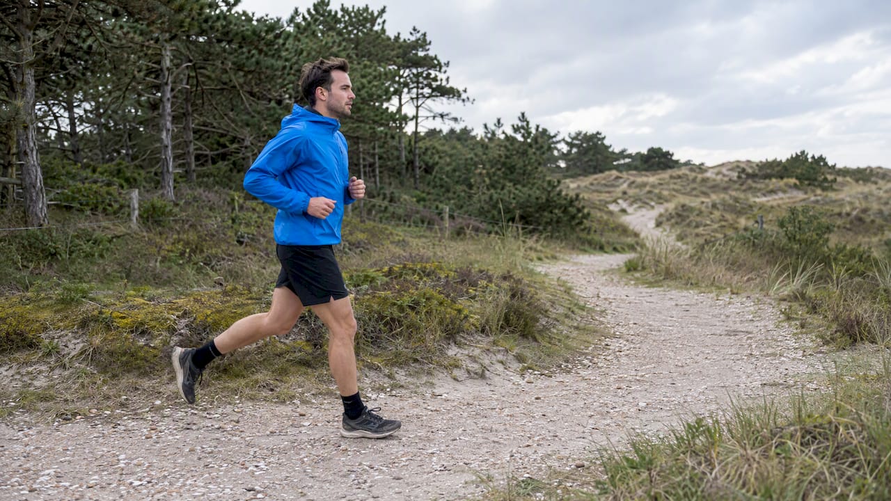 Hardloper op een schelpenpad bij de duinen