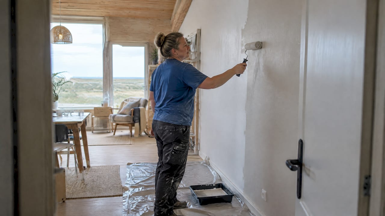 Schilder brengt laagemissie muurverf aan in een loft