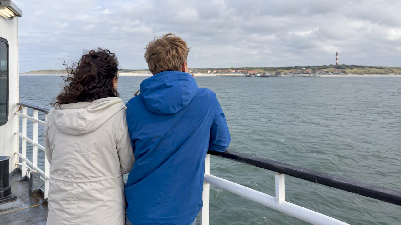 Stel kijkt vanaf de veerboot naar Ameland