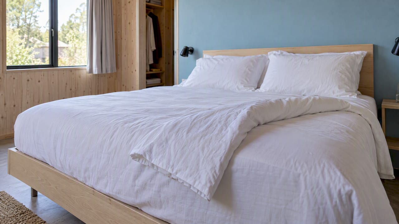 Net opgemaakt bed in een lichte Breeze Loft